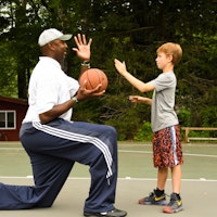 Boys camp counselor coaching camper basketball.jpg?ixlib=rails 2.1