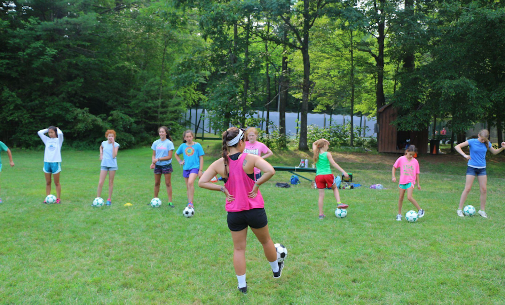 What makes playing sports at camp different from playing sports at school?