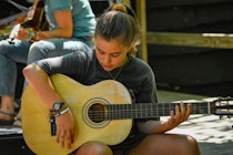 Girl playing guitar at camp.jpg?ixlib=rails 2.1