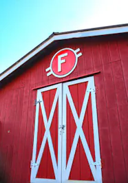 Red barn with Circle F logo above barn doors