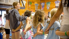 Campers and staff singing arm in arm.jpg?ixlib=rails 2.1