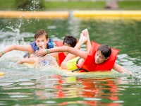 Three boys paddle a paddleboard.jpg?ixlib=rails 2.1
